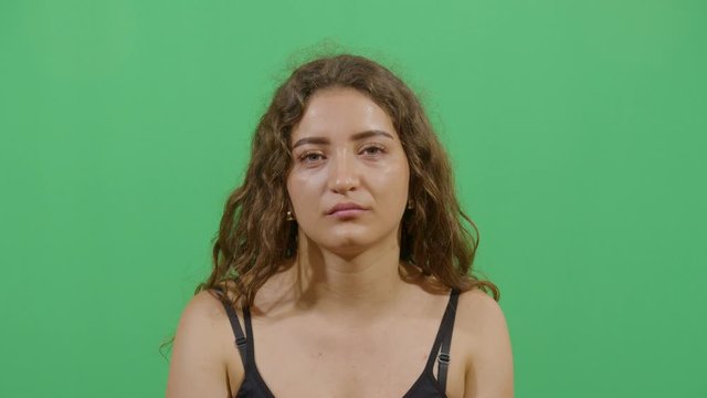 Facial Expression Of A Woman Laughing With Disgust Irony Like It Is Supposed To Be Funny. Studio Isolated Shot Against Green Screen Background