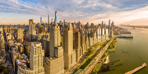 Aerial panorama of New York City waterfront skyline at sunset viewed from above River Side Park, along Joe DiMaggio highway and Riverside Blvd, next to Hudson River.