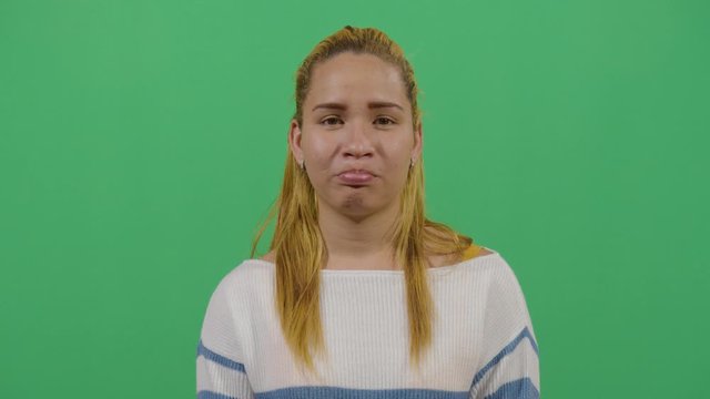 Facial Expression Of A Woman Pouting. Studio Isolated Shot Against Green Screen Background