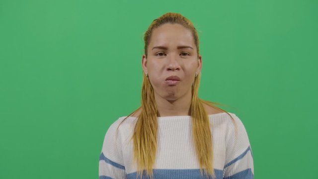 Woman Tongue In Cheeks Funny Facial Expression. Studio Isolated Shot Against Green Screen Background