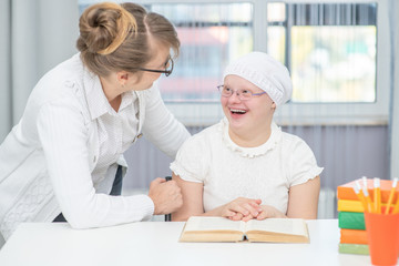 Mother talks with girl with Down Syndrome at home