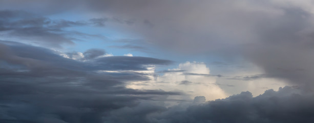 Obraz premium Dramatic Panoramic View of a cloudscape during a dark, rainy and colorful sunset. Taken over Glacier Bay National Park and Preserve, Alaska, USA.