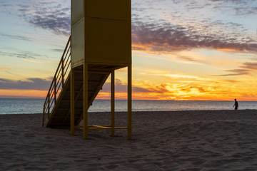 A beach on the Atlantic Ocean at sunset with a lifeguard tower - 295574749