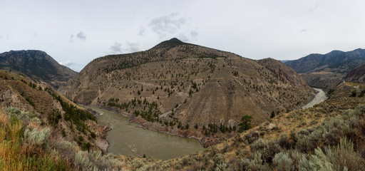 Aerial Panoramic View of Fraser River running in the valley surrounded by Canadian Mountain Landscape during summer time. Taken near Lillooet, BC, Canada.