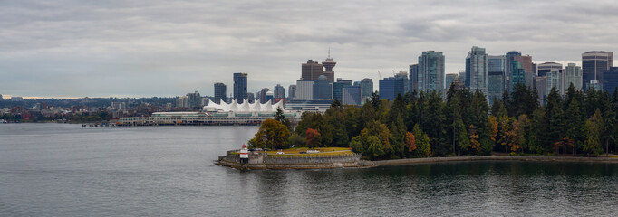 Panoramic Aerial View of Brockton Point Lighthouse in Stanley Park, with Vancouver Downtown, BC, Canada, in the background. Taken during a cloudy summer evening taken from a Boat.
