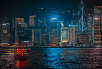 Victoria Harbor Hong Kong night view with junk ship on foreground