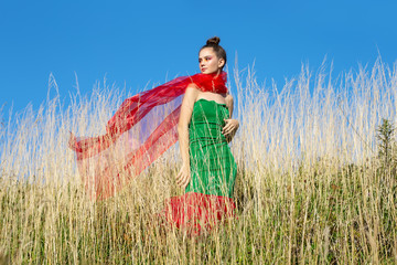 Obraz premium Young beautiful girl model paziruet on the green grass, summer freedom and enjoy the concept.
