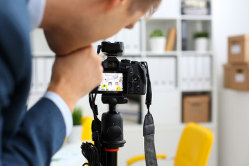 Male arms in suit mount camcorder to tripod