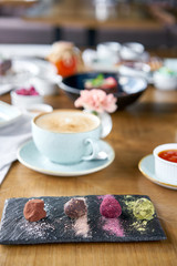 Candy chocolate truffle. Breakfast in the cafe, morning coffee. Cappuccino and lots of desserts on the table.