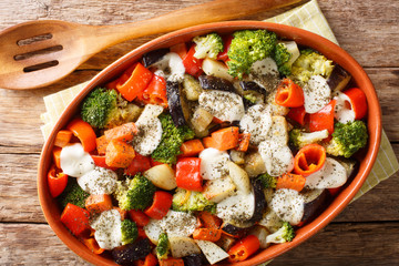 Homemade vegetable casserole with mozzarella cheese close-up in a baking dish. Horizontal top view