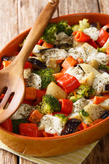 Fresh gratin of vegetables with cheese close-up in a baking dish. vertical