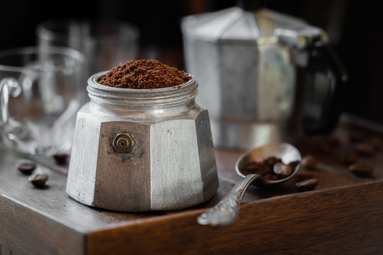 Moka coffee pot filled with brown ground coffee to prepare traditional Italian espresso