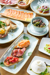 Bruschetta with beef, tomatoes and salmon.. Variety of dishes on the table. Various snacks and antipasti on the table. Restaurant menu. Italian cuisine