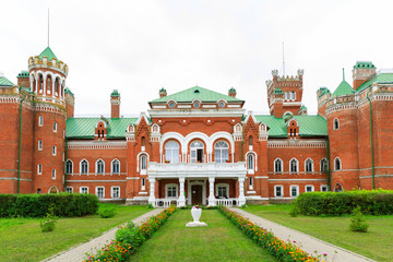 Fototapeta premium Sheremetev castle palace and park ensemble in the village of Yurino on the bank of the Volga, combination of different architectural styles in one building. Cloudy weather at the beginning of summer.