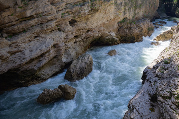 Naklejka na ściany i meble A beautiful mountain river flows between high cliffs
