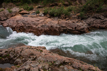 Beautiful stormy river with blue water in granite canyon, Russia, Republic of Adygea