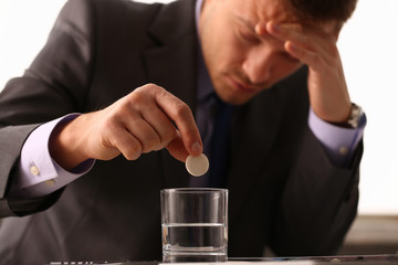 Adult male businessman hold tablet on glass water. On January 1 after celebrating the new year came to work while intoxicated closeup concept