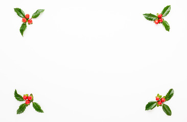 Christmas composition  with branches of spruce and holly with red berries on white background....