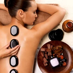 Foto auf Glas Young woman getting hot stone massage in spa salon. © Valua Vitaly