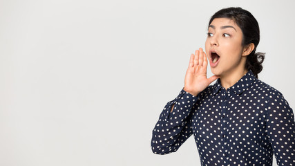 Indian girl on grey studio background make announcement