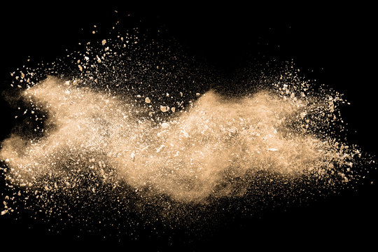 Light brown dust explosion cloud.Brown particles splatter on black background.