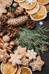 Christmas and New Year holidays preparations. Decorating presents, DIY, celebration concept. Christmas background with homemade gingerbread cookies, evergreen branches and decorations