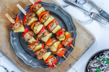 Jerk-style chicken and pineapple skewers with black bean rice - overhead view