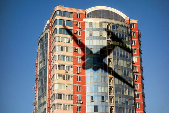 Airplane shadow on skyscraper building. Concept of aviation safety or airport close living. Noise reduction in modern urban lifestyle