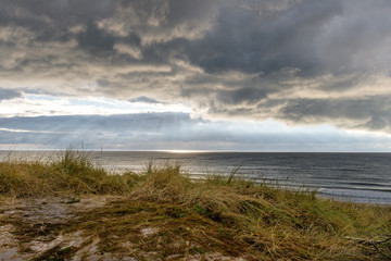 Fototapeta na wymiar Wolkenhimmer am Meer über den Dünen in Dänemark