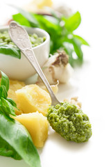 Green italian homemade sauce pesto made of ground basil, garlic, pine seeds, olives and pecorino sardo cheese. Top view isolated on white background