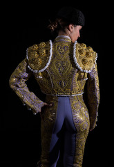 Woman bullfighter by dressing with vest on your back on a black background