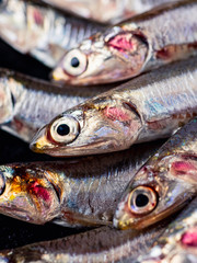 Gruppo di alici fresche su sfondo di ardesia close up