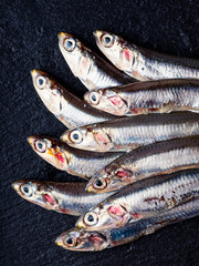 Gruppo di alici fresche su sfondo di ardesia