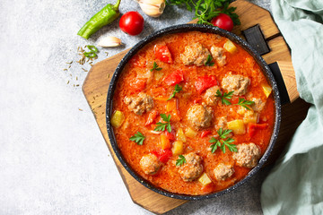 Spanish and Mexican food - Albondigas. Hot stew tomato soup with meatballs and vegetables. Top view on a flat lay. Free space for your text.