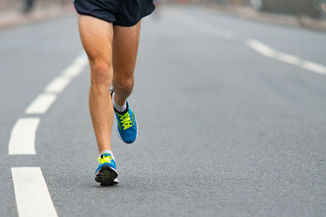 Closeup of the feet of a runner. A man runs along the city road