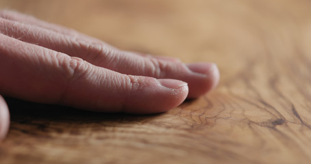 man hand touch oil finished olive wood surface