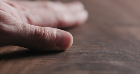 man hand touch oil finished black walnut wood surface