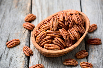 Tasty peeled pecan nuts in wooden bowl.