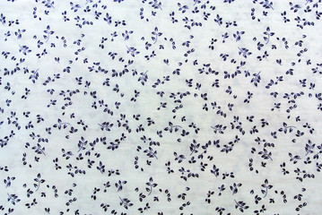 Blue plant leaves print fabric close up background.