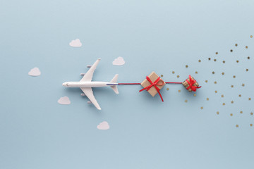 Christmas composition. Airplane flying in sky star gift clouds top view background with copy space for your text. Flat lay.