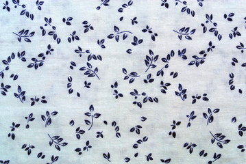 Blue plant leaves print fabric close up background.