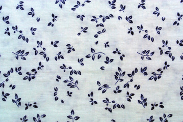 Blue plant leaves print fabric close up background.