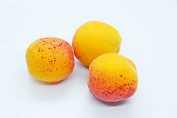 Ripe tasty juicy apricots located on a white background