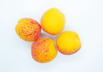 Ripe tasty juicy apricots located on a white background