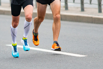 Legs of runners. Marathon race on the city road.  Muscle work