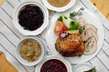 Roast Turkey Breast with Stuffing, Gravy, Apple Sauce, Braised Red Cabbage, Cranberry Sauce on a table