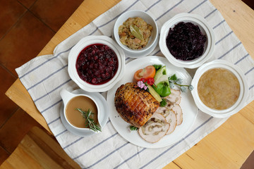 Roast Turkey Breast with Stuffing, Gravy, Apple Sauce, Braised Red Cabbage, Cranberry Sauce on a table