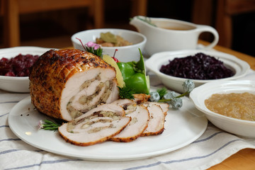 Roast Turkey Breast with Stuffing, Gravy, Apple Sauce, Braised Red Cabbage, Cranberry Sauce on a table