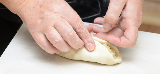 Woman sculpts pies with potatoes. Concept - work in the kitchen