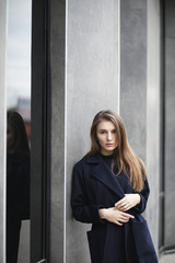 Beautiful girl in a coat in business downtown